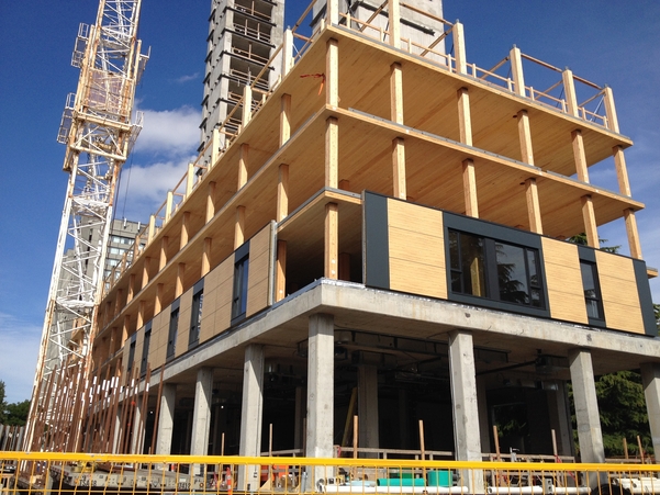 Outdoor daytime view of Brock Commons Tallwood House under construction showing cross-laminated timber (CLT) floor panels set on parallel strand lumber (PSL) and glue-laminated timber (glulam) columns