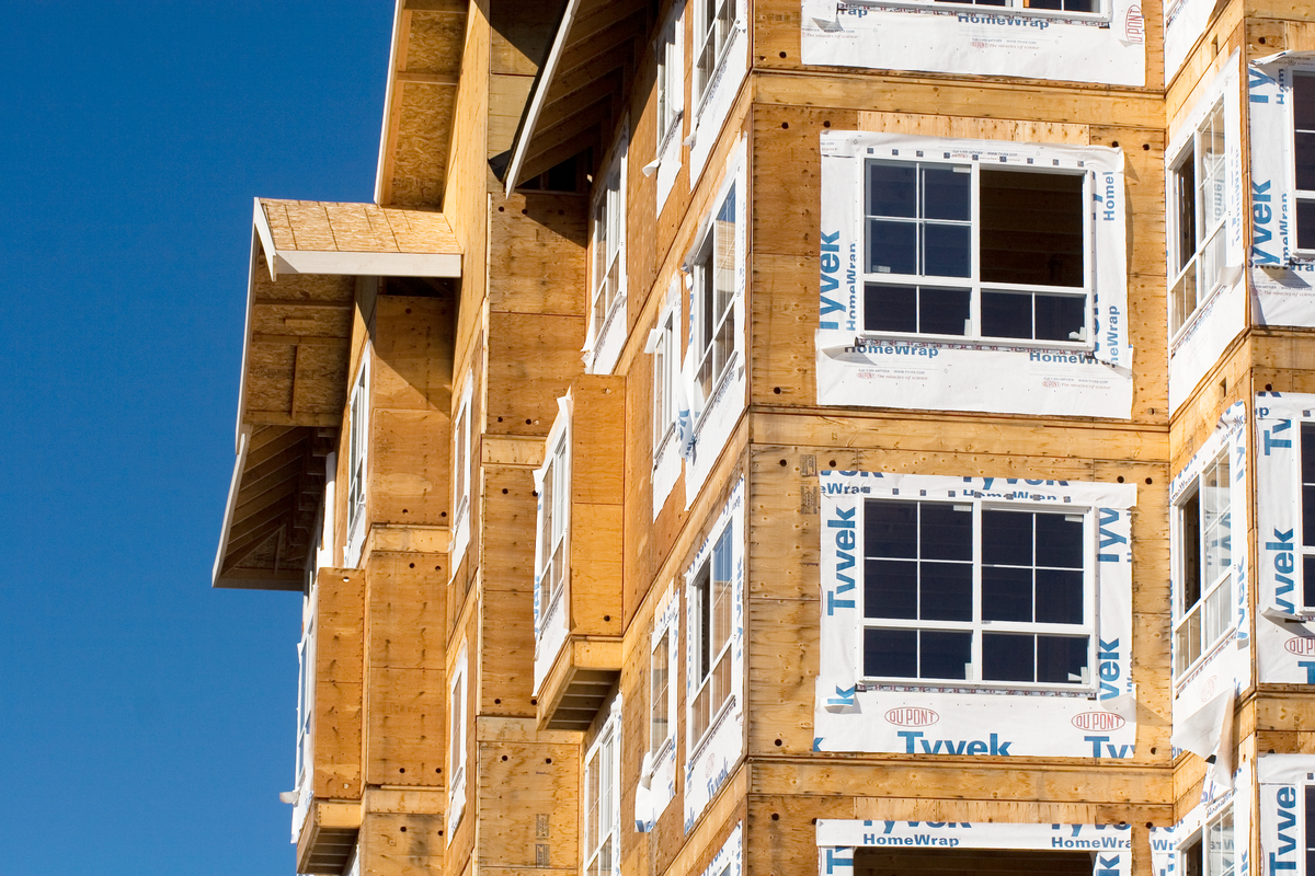 Exterior daytime upward image of mid rise multi unit residential construction project showing extensive use of plywood and oriented strand board (OSB) sheathing